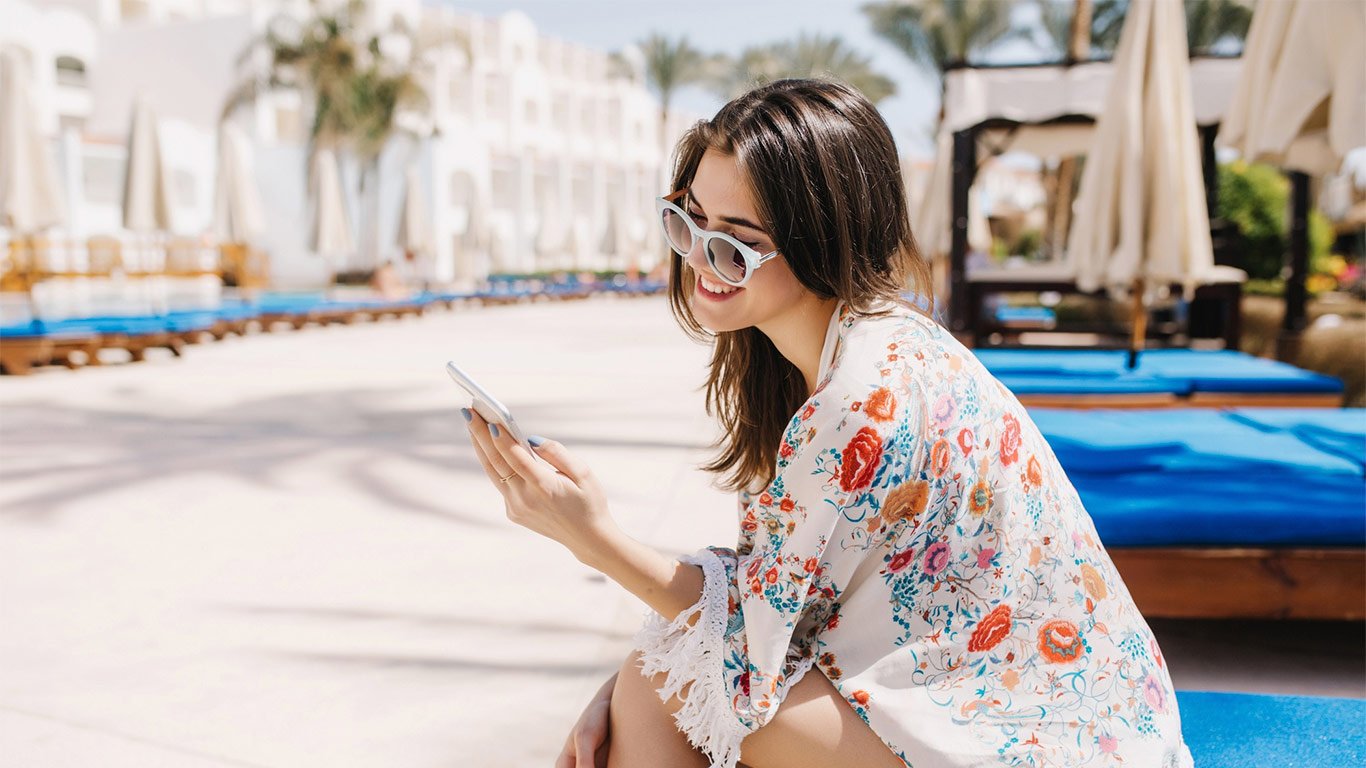 chica-sentada-usando-movil-en-la-piscina